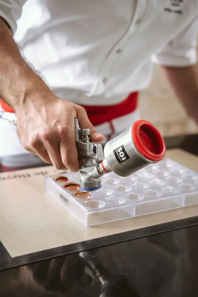 Pulvérisation de chocolat avec un pistolet SATAminijet 4400 B équipé d’un godet en aluminium