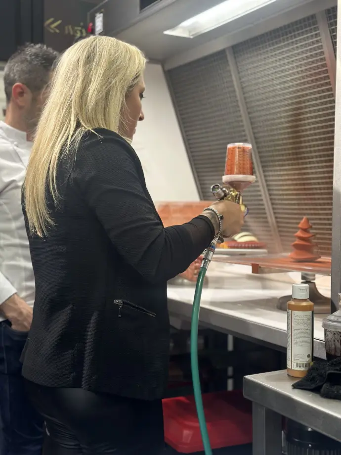 Vanessa de SGI Pastry pulvérisant des pâtisseries avec un SATAjet1000 B RP Pastry au SIRHA 2025