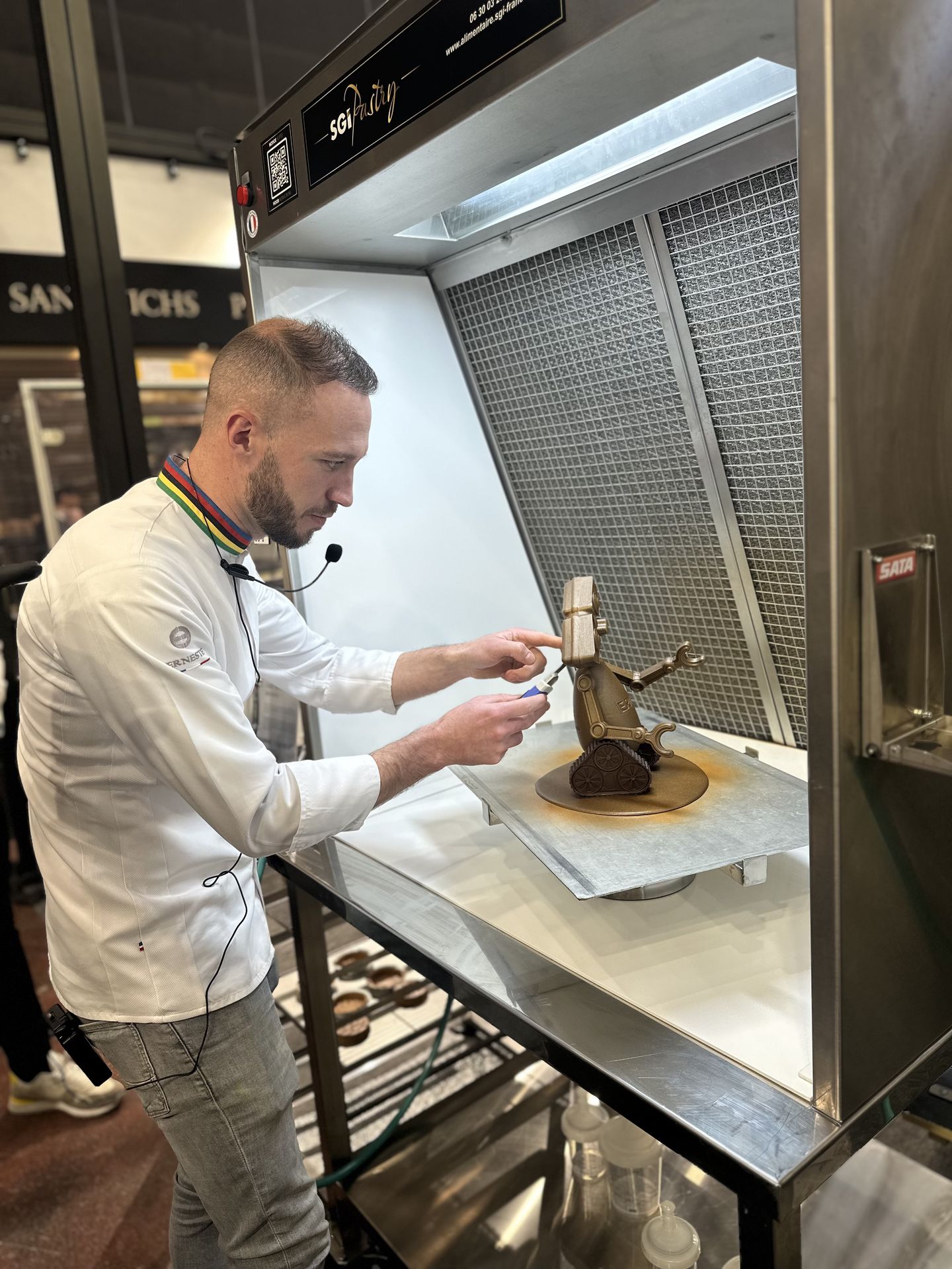 Pâtissier peaufinant sa création dans une hotte SGI Pastry au SIRHA 2025