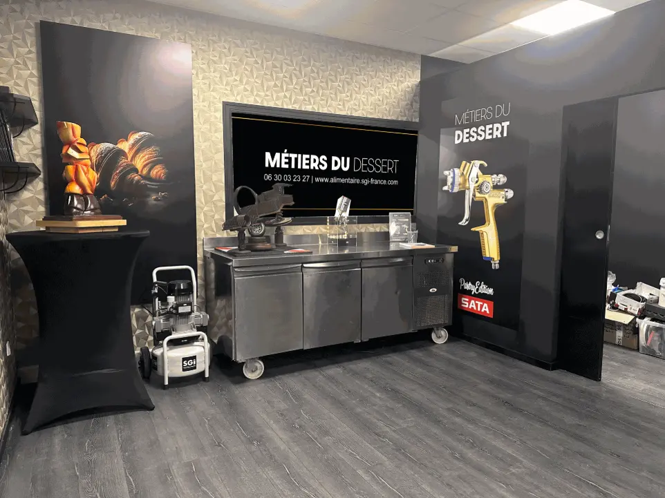 Vue intérieure du showroom SGI Pastry avec équipements professionnels : hottes, compresseurs et pistolets de pulvérisation