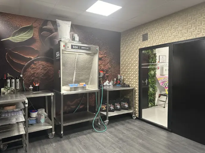 Vue intérieure du showroom SGI Pastry avec équipements professionnels : hottes, compresseurs et pistolets de pulvérisation